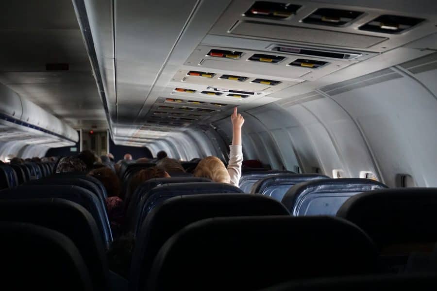 Passenger reaching for the overhead light